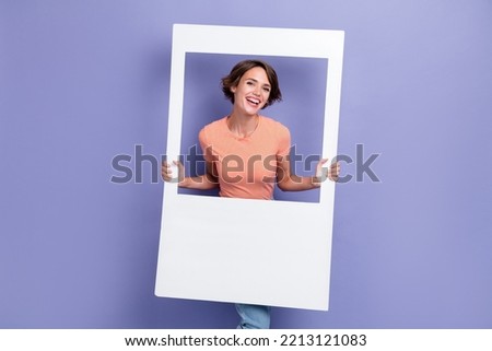 Portrait of satisfied positive lady stylish outfit beaming smile photo studio two arm hold white frame isolated on purple color background