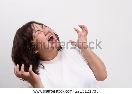 Young Asian oversize women scream and shout with negative emotion, feeling angry and unhappy expression. Portrait shot on white background with copy space. Royalty-Free Stock Photo #2213121985