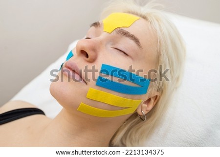 Facial tape, close-up of a girl's face with an anti-wrinkle cosmetology tape. Aesthetic taping of the face. Non-invasive anti-aging lifting method to reduce wrinkles Royalty-Free Stock Photo #2213134375