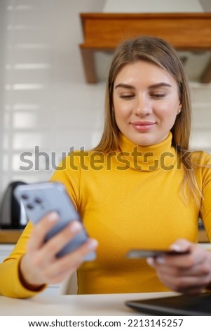 Happy buyer paying online with credit card. Cheerful blonde woman shopping in mobile app 