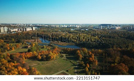 Autumn city park. Trees with colorful leaves. Sports grounds. Autumn landscape. Aerial photography. Flight with slow camera down.