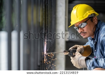 Asian welders in welding and grinding As sparks flew out of the iron grate. and wear a helmet and eye protection