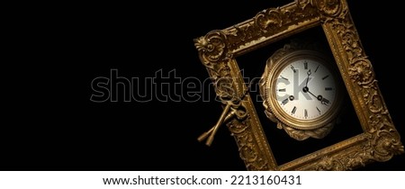 An old antique clock in a golden frame with roman numerals on the dial and ancient keys on a chain, isolated on black Royalty-Free Stock Photo #2213160431