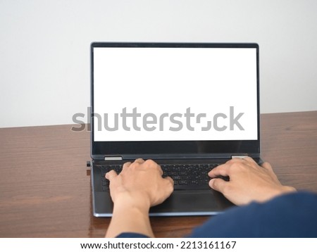 Man hands using keyboard of laptop mockup white screen on the table