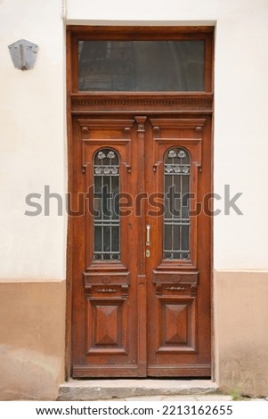 Old ancient wooden door texture in european medieval style. The detailed texture of closed brown aged door from weathered and stained wooden planks and boards