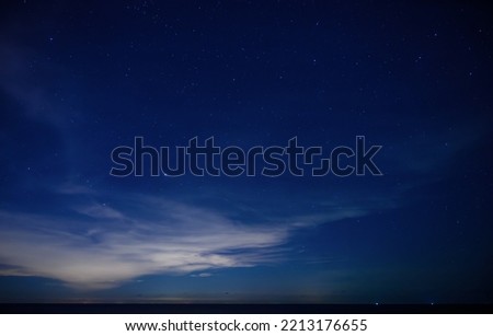 Starry night sky over calm sea beach Royalty-Free Stock Photo #2213176655