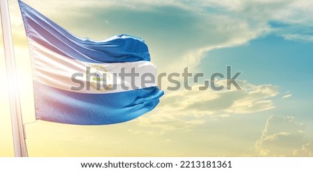 Waving Flag of Nicaragua in Blue Sky. The symbol of the state on wavy cotton fabric.