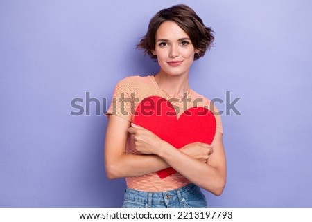 Photo of positive tender lady wear striped outfit hand hug red paper card heart symbol present gift isolated on purple color background