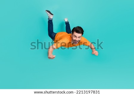 Full body photo of crazy guy playing air gliding flying isolated on cyan color background Royalty-Free Stock Photo #2213197831