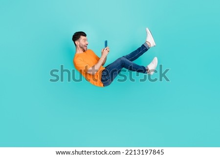 Full body photo of guy blogger falling downward using device incredible news sale isolated on cyan color background Royalty-Free Stock Photo #2213197845