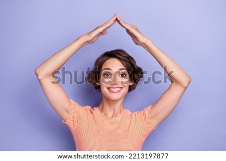Photo of cheerful funny lady wear striped t-shirt showing arms roof smiling isolated violet color background