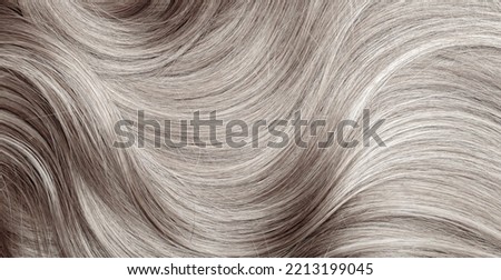 Blond hair close-up as a background. Women's long blonde hair. Beautifully styled wavy shiny curls. Hair coloring. Hairdressing procedures, extension. White hair Royalty-Free Stock Photo #2213199045
