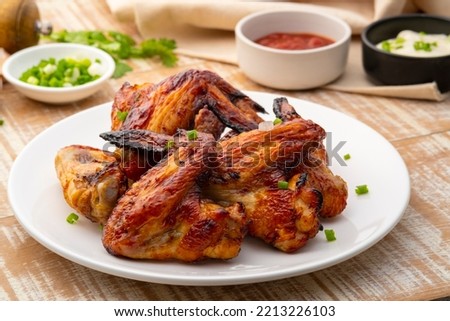 Air Fryer grilled chicken wings on white plate,served with ketchup and mayonnaise Royalty-Free Stock Photo #2213226103