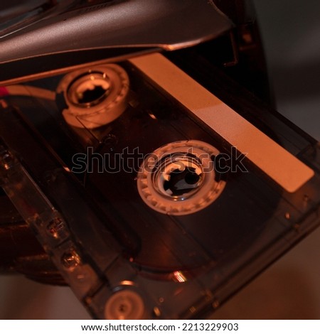 Close-up of a cassette, an audio recording format covered in warm light.