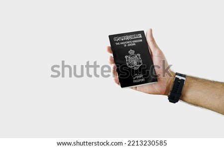 Man holding Jordan Passport in hand on white background with copy space - Jordanian Royalty-Free Stock Photo #2213230585