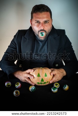 Man dressed up for halloween with a pumpkin in his hand
