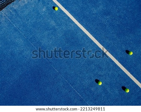 Drone aerial view of four balls in a blue paddle tennis court. Racket sports Royalty-Free Stock Photo #2213249811