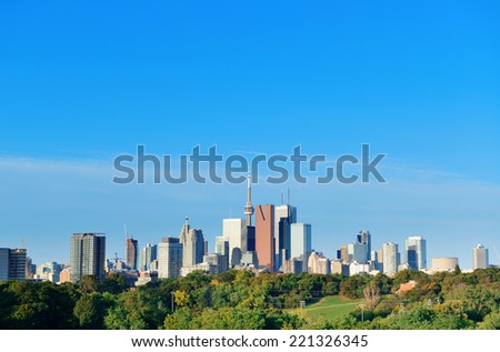 Toronto skyline over park with urban buildings and blue sky