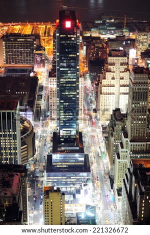 New York City Manhattan street aerial view at night with skyscrapers, pedestrian and busy traffic.