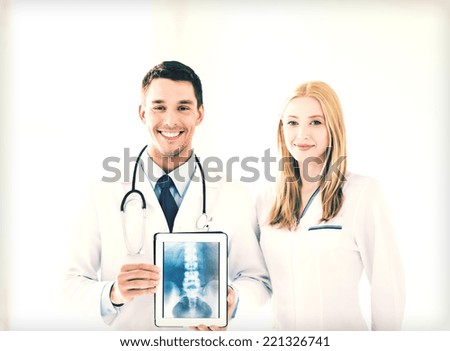 bright picture of two doctors showing x-ray on tablet pc