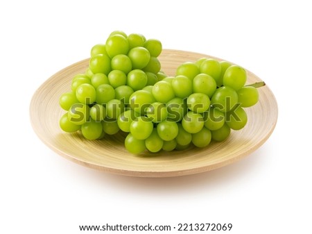Shine Muscat in a wooden dish on a white background. White grapes. Japanese grapes. Royalty-Free Stock Photo #2213272069