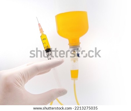 hand doctor wearing white grove holding a syringe and infusion bag medical fluid injection on white background, concept cosmetic, fruit, vitamin C, natural, organic, beauty, treatment, orange