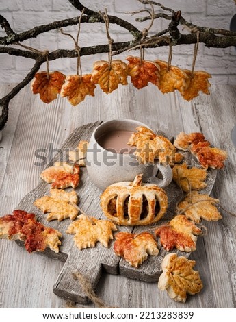 Autumn leaves shaped sugar cookies in branches and cup of chocolate Royalty-Free Stock Photo #2213283839