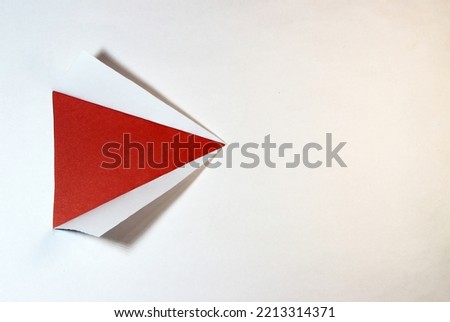 torn white paper in a triangle on a red background