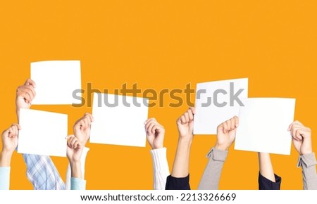 Lots of hands holding white paper labels for texting, white paper labels for scoring, hand holding white blank paper isolated on yellow background. Royalty-Free Stock Photo #2213326669