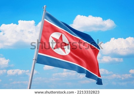North Korea flag and blue sky with clouds.