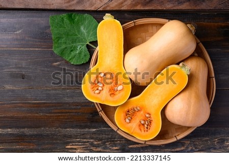 Butternut squash or butternut pumpkin in basket on wooden background, Table top view