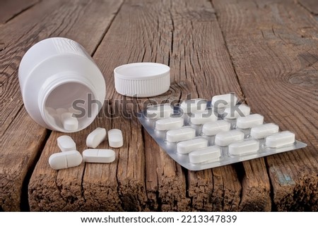 The pills are on the old table. Medicine and old furniture.