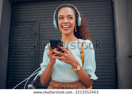Black woman, smile and phone for social media in the city with headphones in joy for 5G connection in the outdoors. Happy African female student smiling for technology or internet on smartphone Royalty-Free Stock Photo #2213352463