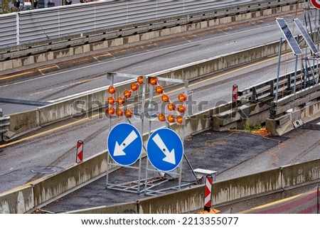Highway bridge with direction signs at junction and blinking lights at Zürich Schwamendingen on a rainy autumn day. Photo shot October 1st, 2022, Zurich, Switzerland.