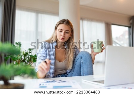 Serious frowning woman sit at workplace desk looks at laptop screen read e-mail feels concerned. Bored unmotivated tired employee, problems difficulties with app