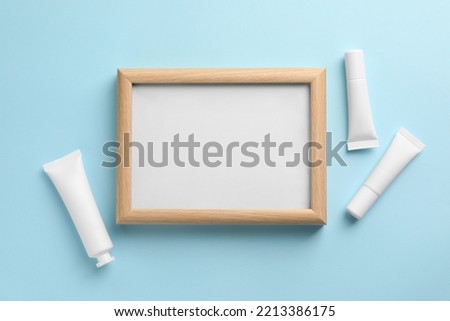 Blank white board with cosmetics on turquoise background, flat lay. Space for text