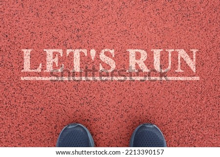 Feet stand in front of the inscription lets run. The concept of sports motivation, healthy lifestyle