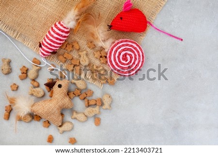 Cat toys and treats on mottled grey with ample copy space