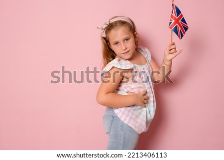 Cute young girl holding a flag of United Kingdom Great Britain. British flag.Learn English. International language school concept