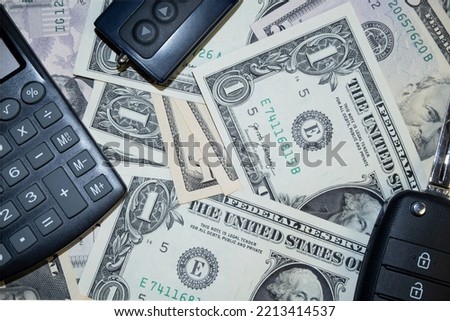 car keys and canculator on the photo of money. calculate the cost of a car trip