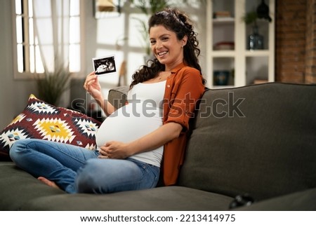 Pregnant woman with ultrasound photo. Beautiful pregnant woman enjoy at home. 