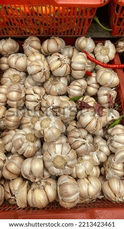 Stack of onions in red plastic container for sale in a market
