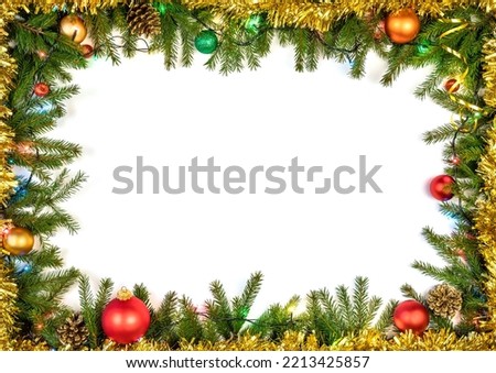 Christmas frame made of fir branches baubles cones and Christmas multicolored electric lights on white background