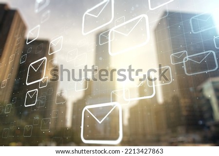 Double exposure of abstract virtual postal envelopes hologram on modern skyscrapers background. Electronic mail and spam concept
