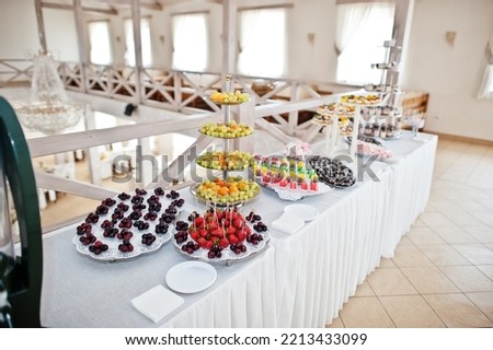 Beautiful wedding candy bar with sweets, fruits and food. Wedding banquet table