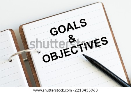 Notepad with GOALS OBJECTIVES text inscription on notepad on a light background