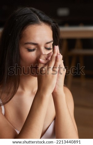 Mind Harmony. Closeup Shot Of Young Beautiful Woman Meditating With Closed Eyes, Calm Brunette Female Practicing Meditation Or Praying, Keeping Hands In Namaste Gesture Near Face.