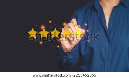 Close-up of hand holding a pen writing best excellent services satisfaction client giving a five-star rating. Customer feedback, service evaluation, experience, and satisfaction concept