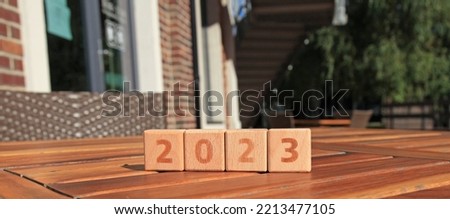 Set of wooden square cubes and numbers on wooden table shows 2023. Symbol of New Year Eve. Сhristmas, holidays and celebration concept. New Year of 2023, the year of the black water rabbit