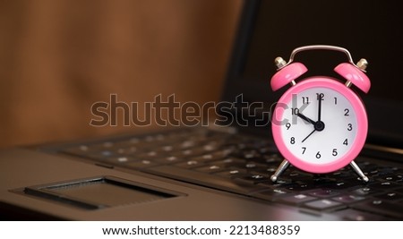 Alarm clock on a laptop. Save or manage time, daylight savings banner, background with copy space.